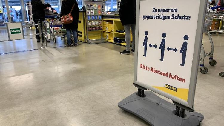 Ein Hinweisschild bittet die Kunden im Kassenbereich Abstand zum nächsten Kunden zu halten. 