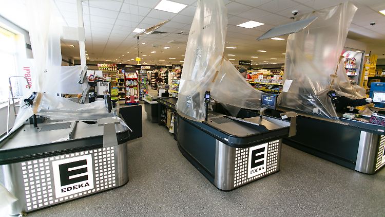 In dieser Edeka-Filiale werden die Arbeitsplätze der Kassiererinnen und Kassierer für ihren Schutz mit Plastikfolie abgehängt.
