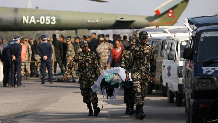 Soldaten transportieren den Leichnahm eines Opfers.