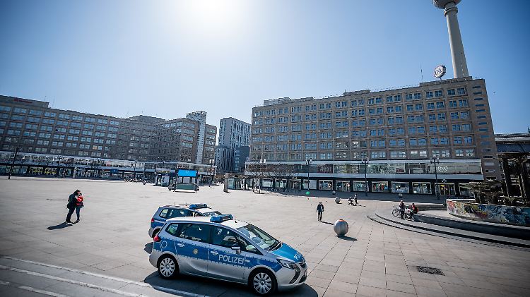 Die Polizei patrouilliert über einen nahezu menschenleeren Alexanderplatz in Berlin. 