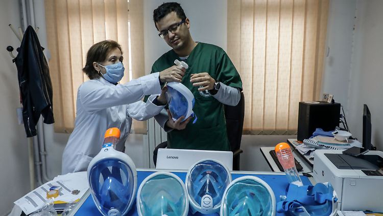 Der tunesische Arzt Youssef El Hachemi und eine Kollegin wandeln eine Tauchermaske zu einer Maske für die Beatmung von Covid-19-Patienten um.