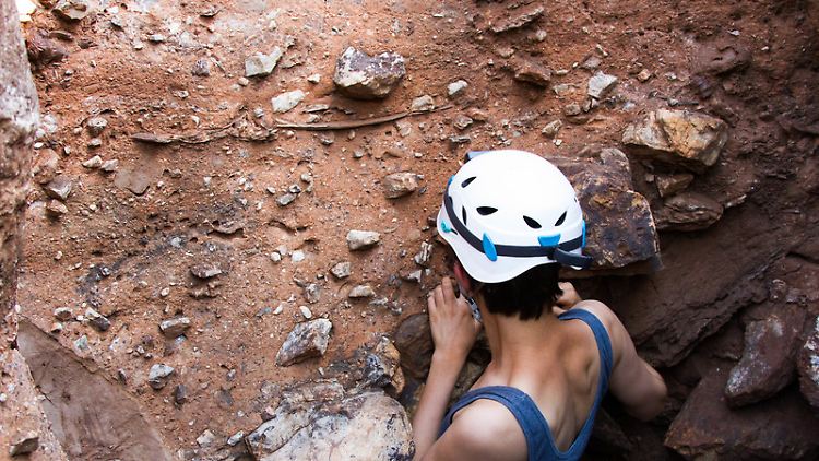 La-Trobe-Doktorandin Angeline Leece vor dem fossilführenden Gestein in der Karsthöhle Drimolen.