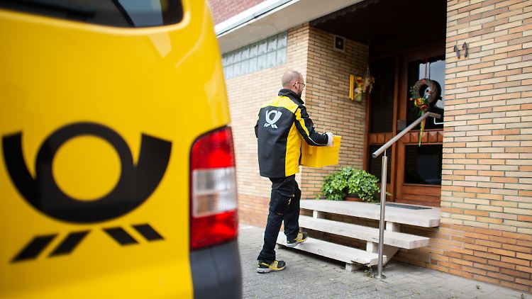 Pilotprojekt in Heinsberg: Ein Postzusteller trägt Lebensmittel zu einer Anwohnerin in Quarantäne.