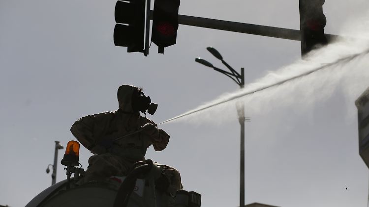 Ein Freiwilliger versprüht in Teheran Desinfektionsmittel.