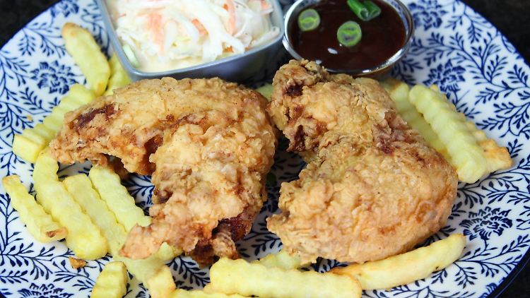 Knusprige Hähnchenflügell - und dazu Krautsalat und Pommes frites.