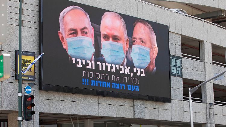 Auf der Anzeigentafel bereits mundschutztragend vereint: links Benjamin Netanjahu, rechts Benny Gantz.