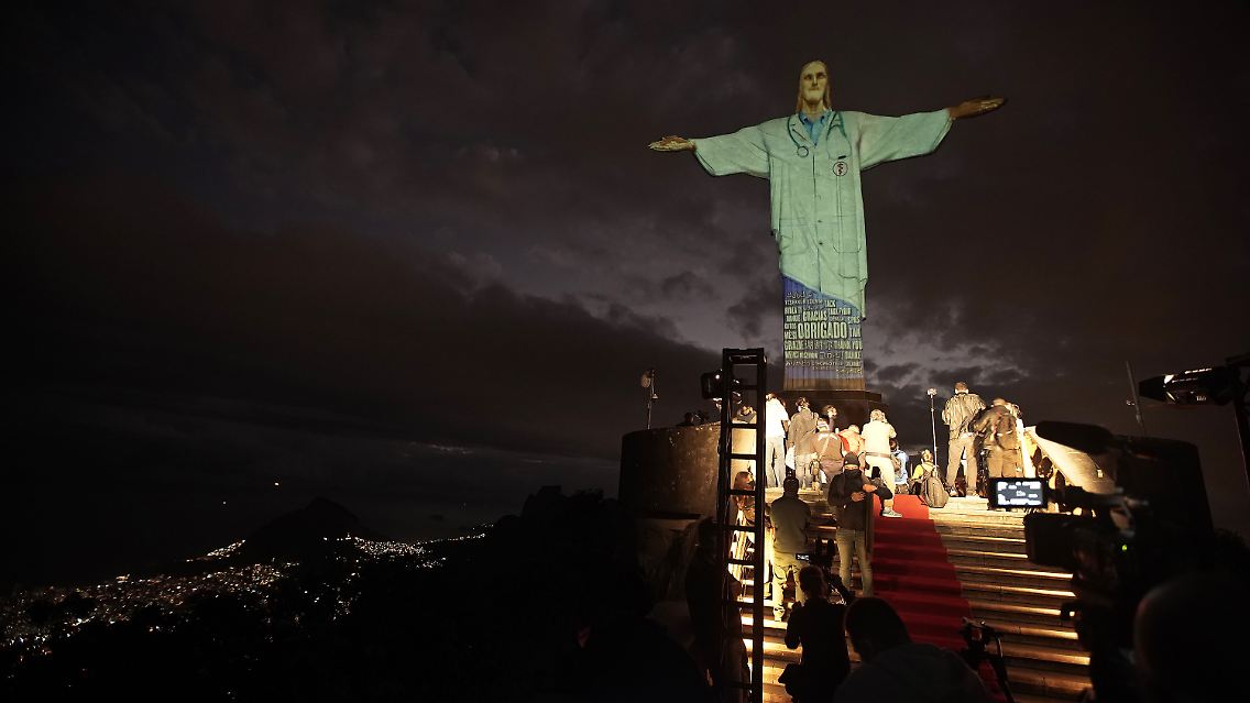 Zu Ehren der medizinischen Kräfte im Einsatz gegen das Coronavirus wurde die Cristo-Statue im brasilianischen Rio de Janeiro mit verschiedenen Motiven - wie etwa einem Arztkittel - geschmückt.