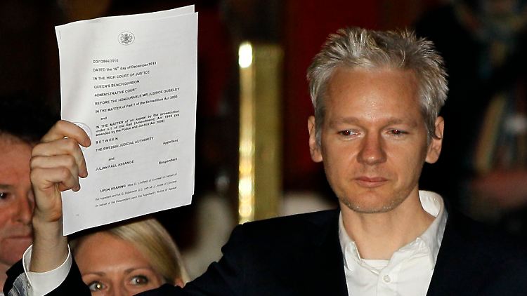 Julian Assange kurz nach seiner Freilassung. Er zeigt der versammelten Presse eine Gerichtsurkunde.