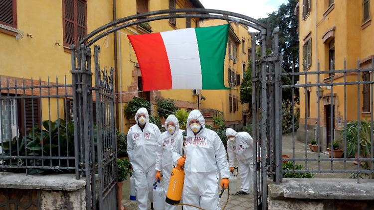 Arbeiter desinfizieren Gehwege in Rom. Auch solche Reinigungsmittel wurden Italien von anderen Ländern geschickt.