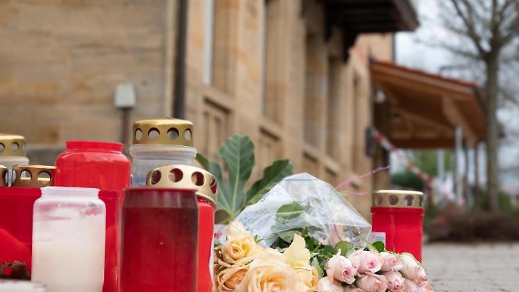 Blumen und Kerzen vor dem Tatort in Rot am See. 