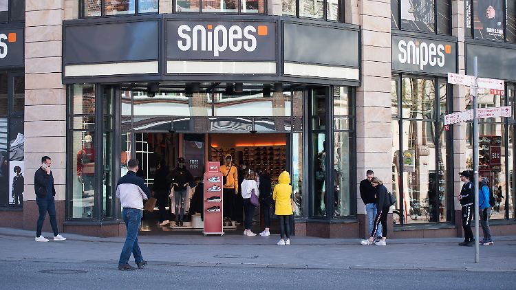 Kunden stehen vor einem Geschäft auf der Hamburger Mönckebergstraße Schlange, weil nur eine begrenzte Menge von Menschen sich gleichzeitig im Laden aufhalten darf.
