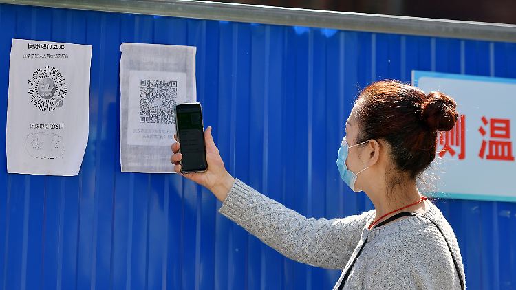 Eine Anwohnerin von Wuhan scannt einen Gesundheits-QR-Code am Eingang zu ihrer Gemeinde. Im Ursprungsort der Pandemie müssen Bewohner einen grünen Code nachweisen.