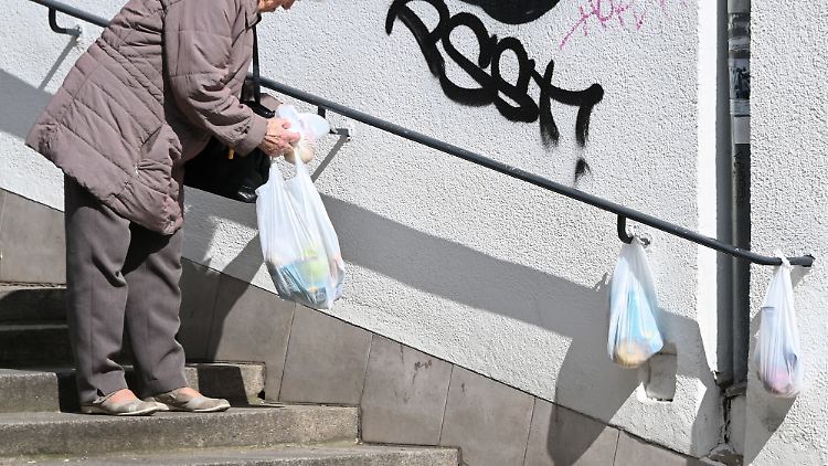 Eine Frau nimmt sich eine gefüllte Tüte vom "Gabengeländer" in der Treppenstraße in Kassel. Die Lebensmittelspenden von Privatpersonen werden von Bedürftigen gut angenommen. 