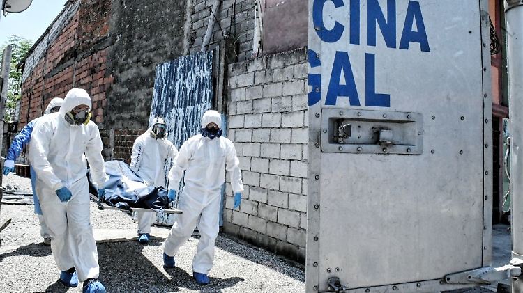 Polizisten einer Sondereinheit transportieren eine Leiche. Das Gesundheitssystem Ecuadors und Beerdigungsunternehmen sind völlig überlastet.