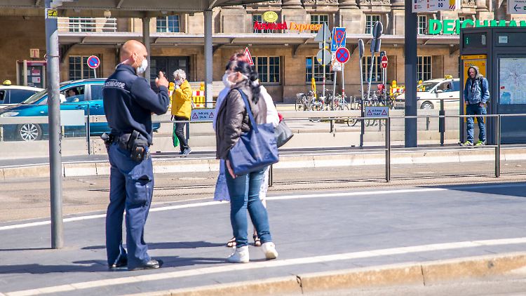 In Leipzig erklärt ein Mitarbeiter der Verkehrsbetriebe Passanten das richtige Verhalten während der Corona-Krise