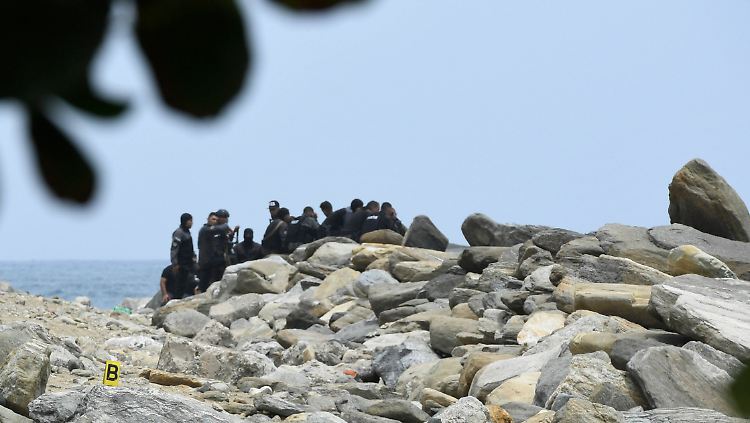 Sicherheitskräfte überprüfen einen Küstenabschnitt, an dem die angebliche Invasion stattgefunden haben soll.