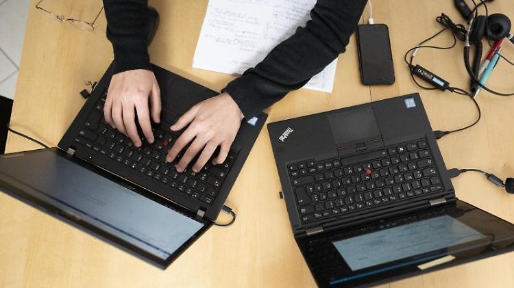 Eine Frau arbeitet am Küchentisch an ihren Laptops. Foto: Lisa Ducret/dpa/Archivbild