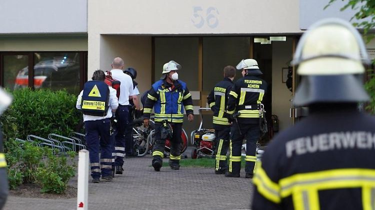 Einsatzkräfte der Polizei und Feuerwehr bei dem Großeinsatz vor dem Mehrfamilienhaus in Achern.