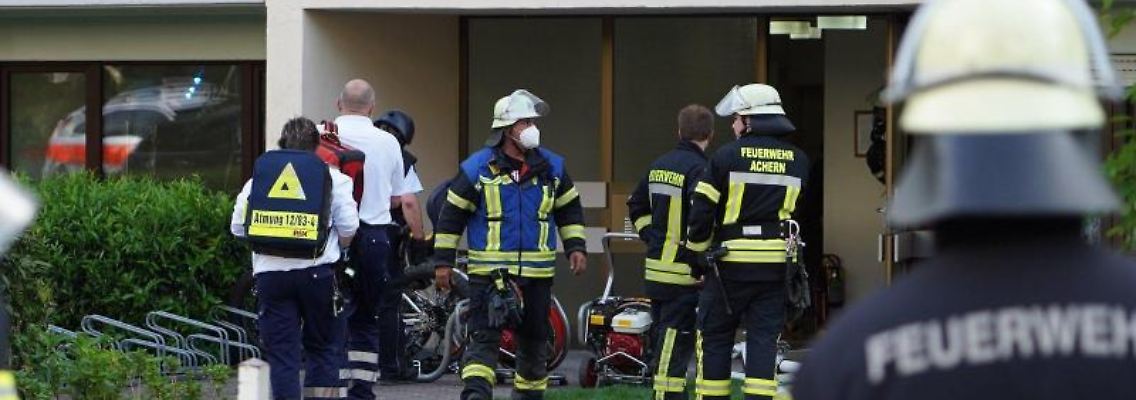 Einsatzkräfte der Polizei und Feuerwehr bei dem Großeinsatz vor dem Mehrfamilienhaus in Achern. Foto: Benedikt Spether/dpa