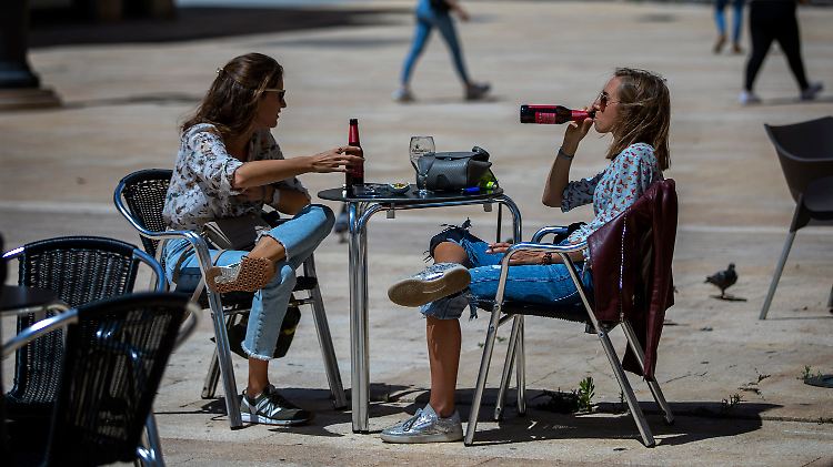 Zwei Frauen im spanischen Tarragona trinken ein Bier in der Sonne.
