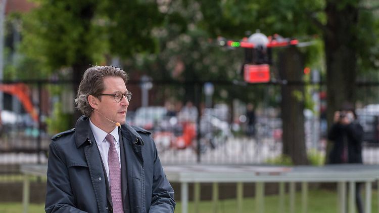 Nein, das im Hintergrund ist kein Ufo, sondern eine Transportdrohne, deren Vorteile Verkehrsminister Scheuer in Berlin anpries.