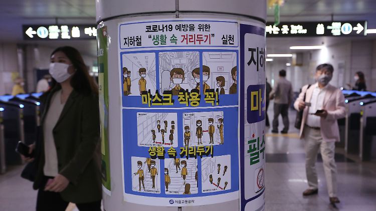 "Trag eine Maske und halte Abstand" steht auf einem Plakat in Seoul.