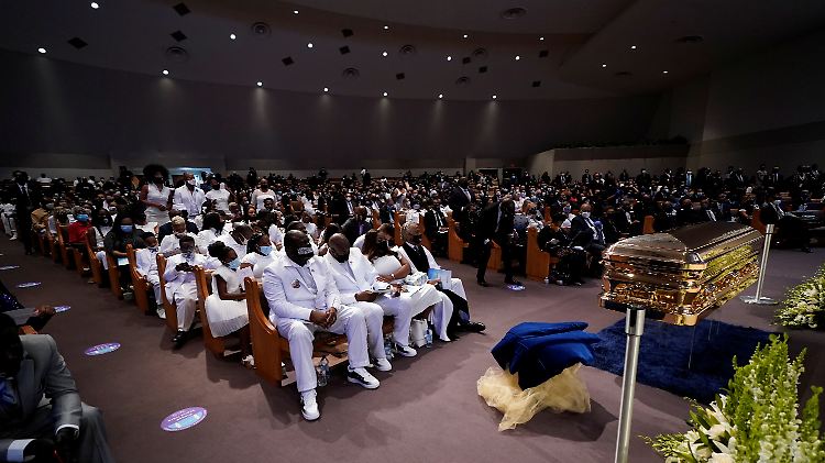 George Floyd wird in einem goldfarbenen Sarg beigesetzt.