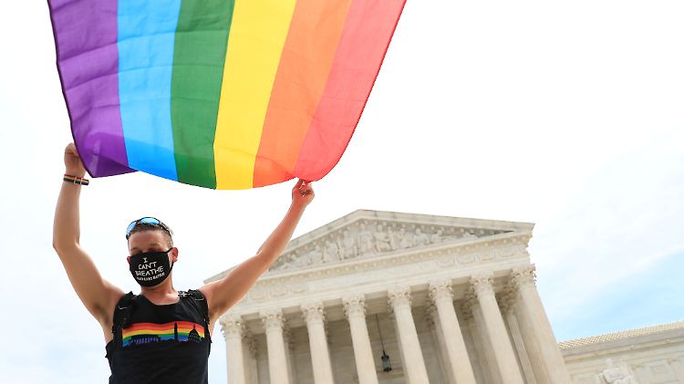 Ein Aktivist lässt vorm Supreme Court, dem höchsten Gericht der USA, die Regenbogenfahne wehen.