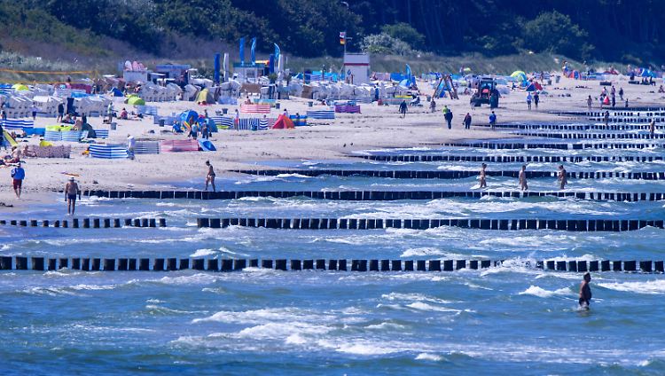 Urlauber nutzen das sonnige Wetter am Strand von Warnemünde.