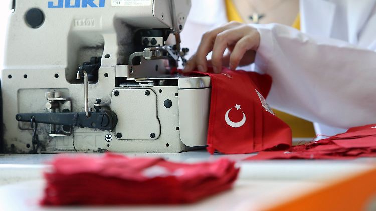 Eine Frau in Ankara näht eine Mund-Nase-Bedeckung mit der türkischen Flagge als Motiv.