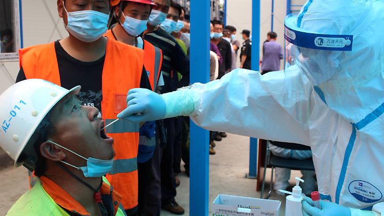 Ein Bauarbeiter wird in Peking auf das Coronavirus getestet.