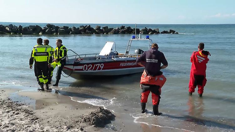 Rettungskräfte stehen am Strand von Ahrenshoop.