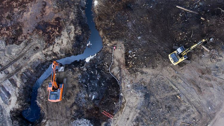 Einsatzkräfte veruchen in Norilsk mit Baggern die Ausbreitung des Ölteppichs zu verhindern. 