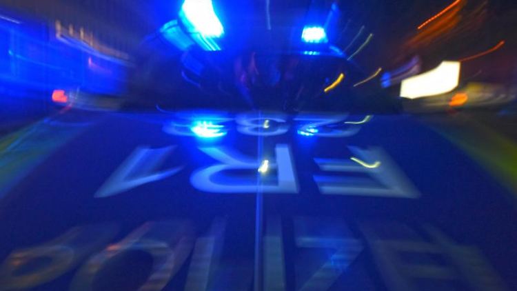 Ein Polizeifahrzeug steht mit Blaulicht auf der Straße.