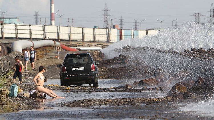 Auch im sommerlichen Norilsk geht man am See baden - zwischen Versorgungsleitungen, Kraftwerken und Autos.