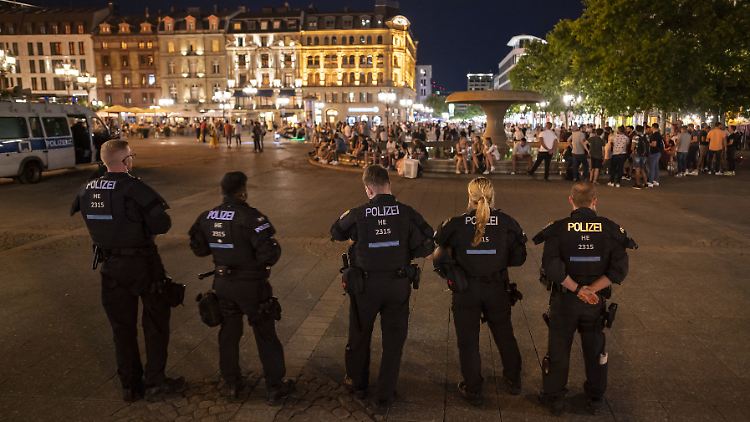 Polizisten stehen am Abend auf dem Frankfurter Opernplatz.