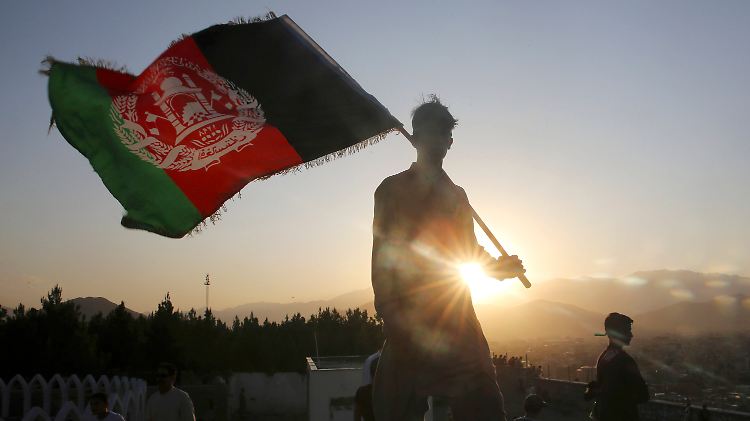 Ein Mann schwenkt die afghanische Fahne - das Land wartet noch immer auf Frieden.