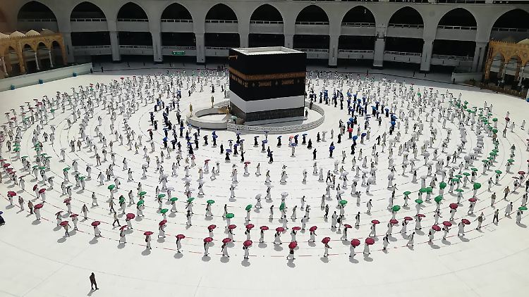 Mit Mindestabstand umkreisen Hunderte Pilger die Kaaba, das kubische Gebäude der großen Moschee.
