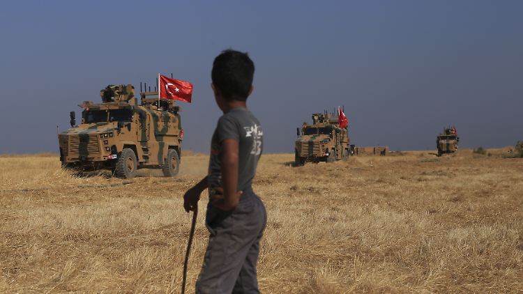 Eine Junge beobachtet eine türkische Patrouille in Syrien.