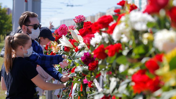 An dem Ort in Minsk, wo ein Demonstrant am Montag ums Leben kam, legen Menschen Blumen nieder.