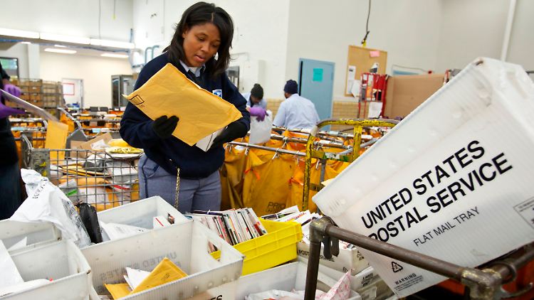 Eine Briefträgerin von USPS sortiert Briefe in Chicago.