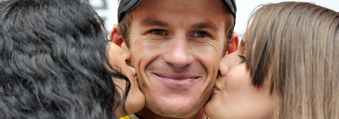 Ein Bild, das es so bald nicht mehr geben wird: Der ehemalige australische Radprofi Michael Rogers wird bei einer Siegerehrung im Jahr 2010 von zwei Hostessen geküsst.