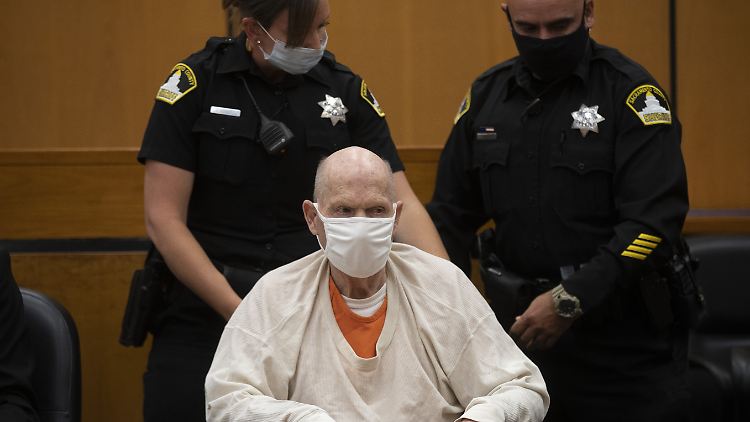 Joseph James DeAngelo, bekannt unter dem Namen "Golden State Killer", wird von zwei Polizisten in einem Rollstuhl während einer Pause aus dem Gerichtssaal geschoben.