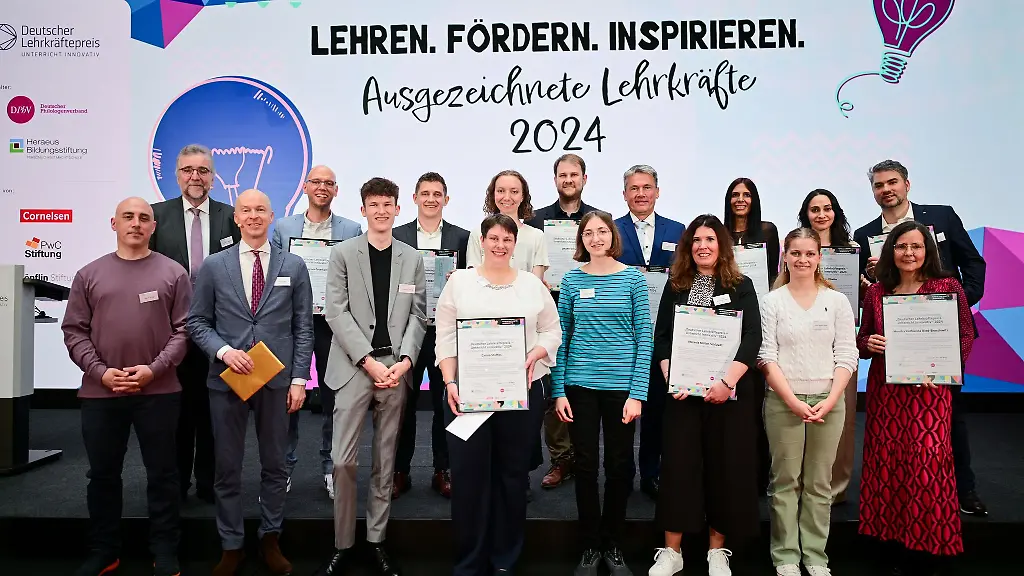 Die-Preistraegerinnen-und-Preistraeger-in-der-Kategorie-Ausgezeichnete-Lehrkraefte-sowie-vereinzelte-Schuelerinnen-und-Schueler-stehen-waehrend-der-Preisverleihung-des-Deutschen-Lehrkraeftepreises-zusammen
