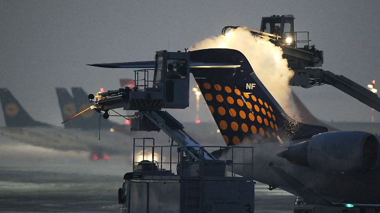 Arbeiter enteisen in Düsseldorf Flugzeuge.