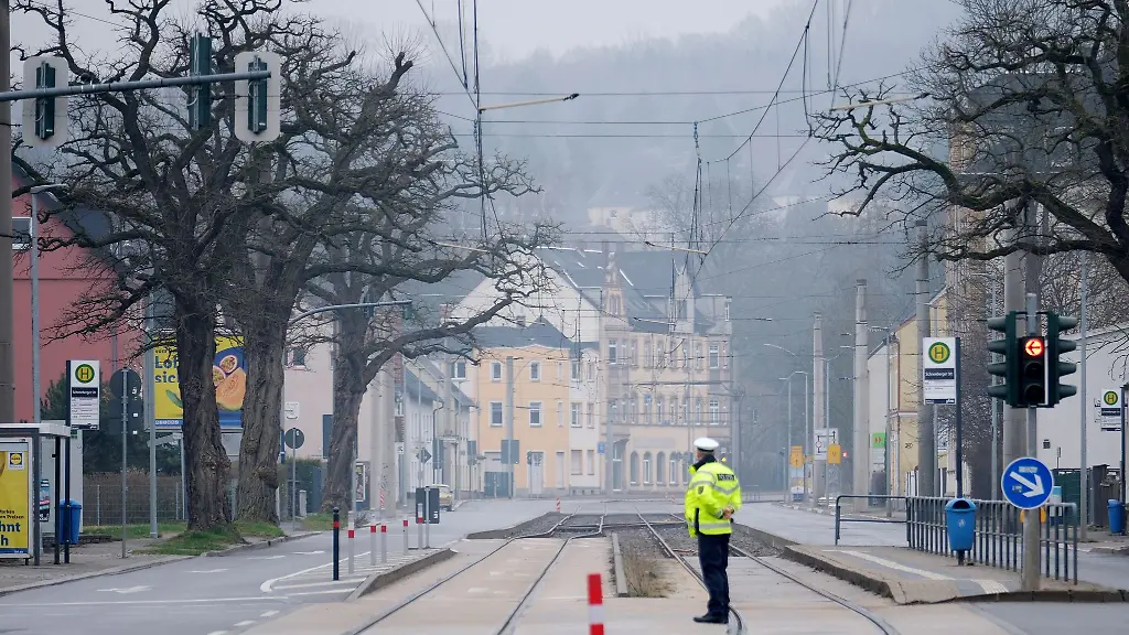 Ein-Polizist-steht-auf-einer-Kreuzung-im-Stadtteil-Altchemnitz-Wegen-der-geplanten-Entschaerfung-Weltkriegsbombe-muessen-hier-viele-Einwohner-ihre-Haeuser-verlassen