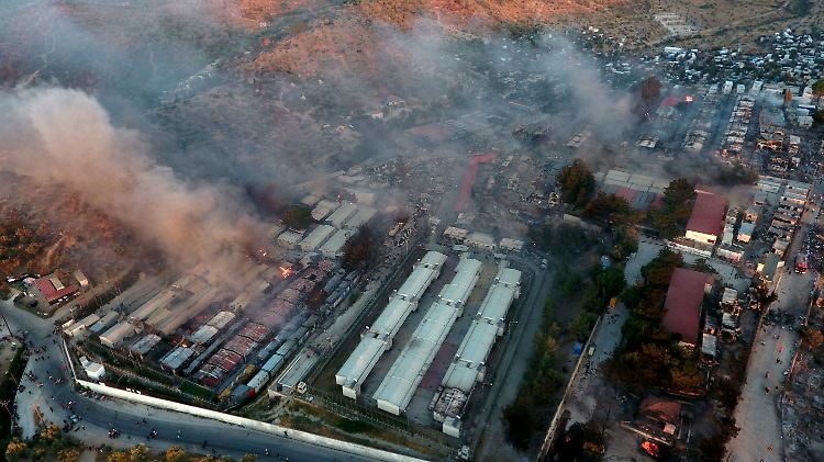 Menschen flüchten in der Nacht mit dem, was sie tragen können vor den Flammen im Flüchtlingscamp Moria auf Lesbos.