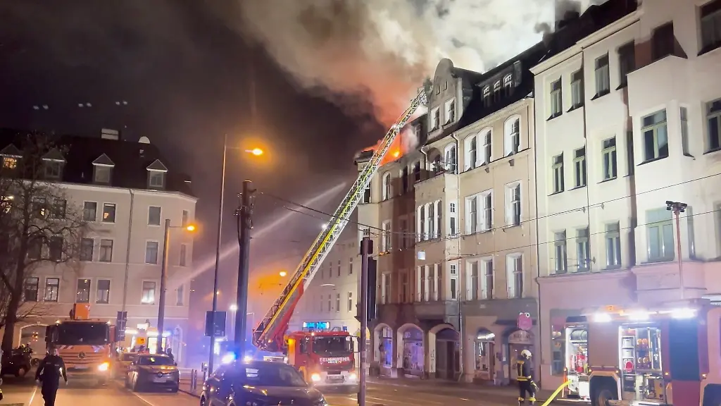 Einsatzkraefte-der-Feuerwehr-loeschen-einen-Brand-in-einem-leerstehenden-Haus-im-Zentrum-von-Halle