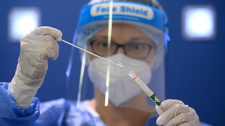 Eine Ärztin hält am Flughafen Dresden einen Coronavirus-Test in den Händen.