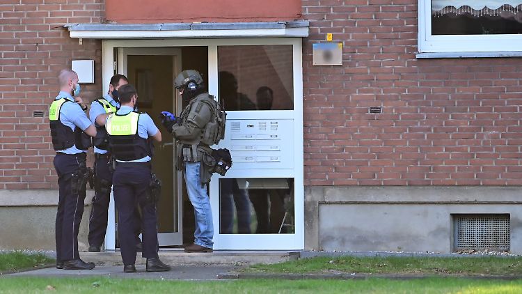 Einsatzkräfte stehen vor der Eingangstür eines Mehrfamilienhauses in Krefeld.